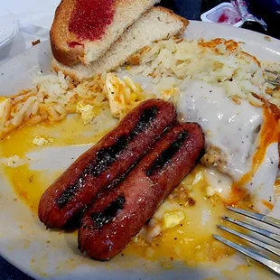 Chicken fried steak platter with hash browns, two eggs over easy and a side spicy sausage.