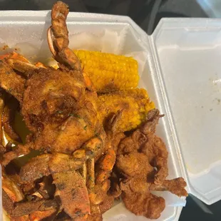 a tray of fried crabs and corn on the cob