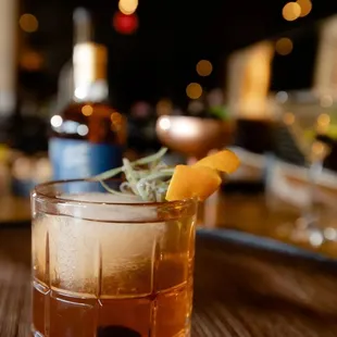 a glass of whiskey with a garnish