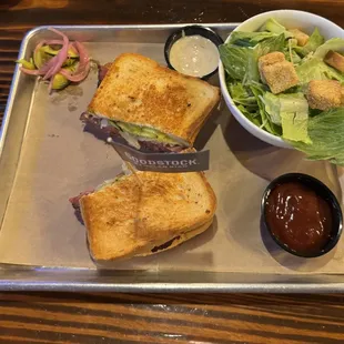 Spicy Pastrami Brisket sandwich with a side salad.