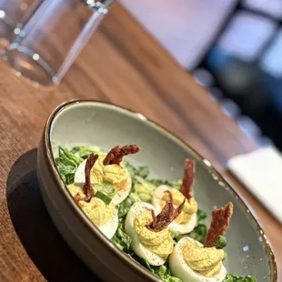a bowl of deviled eggs and bacon
