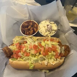Shrimp po boy sandwich with side of beans and potato salad