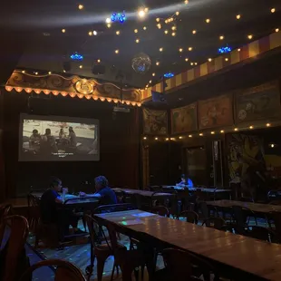 eople sitting at tables watching a movie