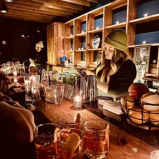 a woman at a bar with drinks