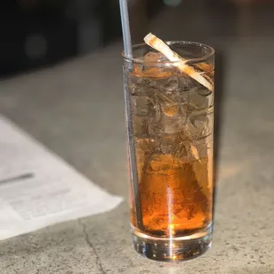 a glass of alcohol with a cigarette sticking out of it