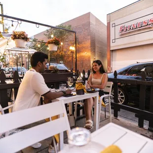 a couple sitting at a table outside