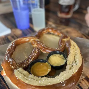 Fresh pretzel with cheese sauce and mustard sauce
