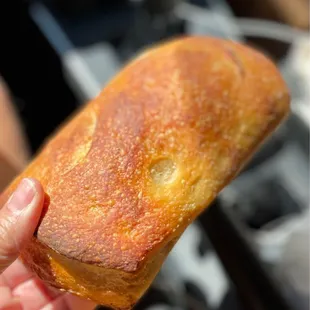 a hand holding a piece of bread