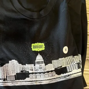 a black t - shirt with a picture of a city on it