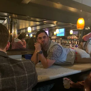 a man laying on a bar counter