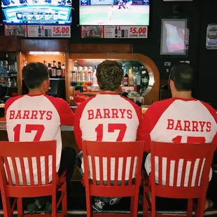 three baseball players sitting at the bar