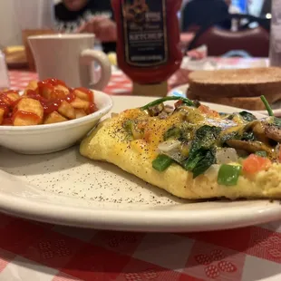 Veggie omelet with hash browns, toast, and coffee