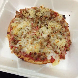 a pizza in a styrofoam container
