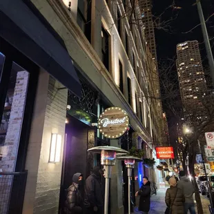 people walking down a city street at night