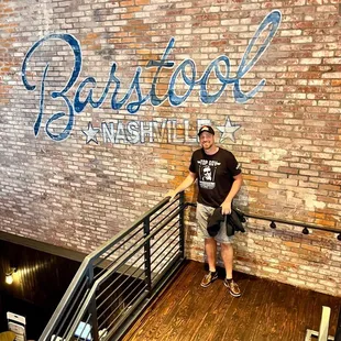  a man standing in front of a brick wall