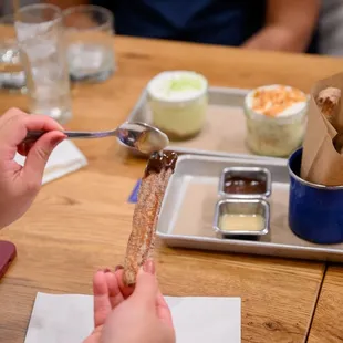 a person holding a spoon over a spoon