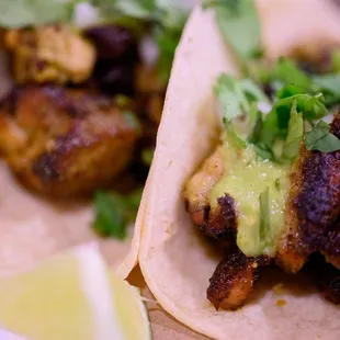 a plate of tacos with chicken and guacamole