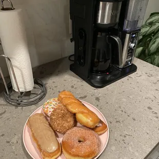 a plate of doughnuts and a coffee maker
