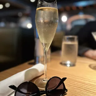 a glass of wine and a pair of sunglasses