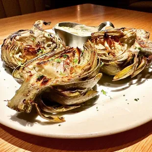 a plate of artichokes with dipping sauce
