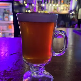 a glass of beer on a bar