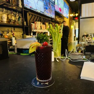 a bloody drink with a garnish of celery and a garnish of lime