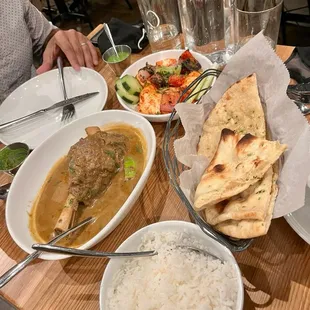 Lamb Shank Nihari, Paneer Tikka, and Garlic Naan on top of bread basket