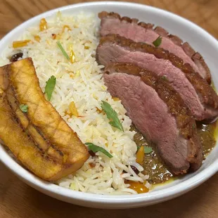 Duck Basant, seared duck breast, coconut &amp; tamarind sauce, jeweled saffron rice, carmelized plantain.