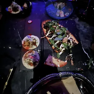 a table with pizzas and drinks