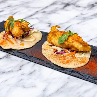 two pieces of food on a slate platter