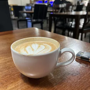 a cup of cappuccino on a wooden table