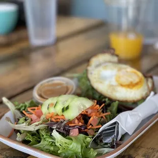 a plate of salad with a fried egg on top