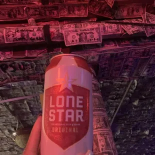 a hand holding a can of lone star