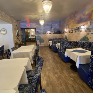 a dining room with blue chairs and white tablecloths
