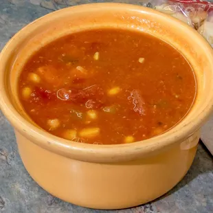 a bowl of soup and a bag of chips