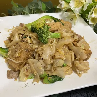 a plate of noodles with meat and broccoli