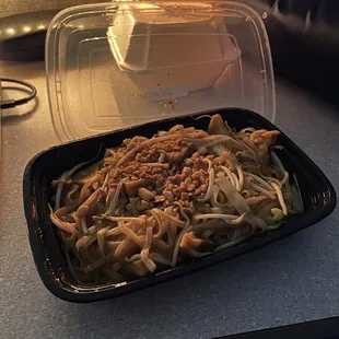 a plate of noodles and a plastic container