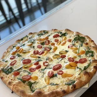 a pizza with tomatoes and spinach