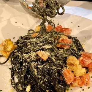 Squid ink pasta with a lobster cream sauce, and chunks of tomato and lobster