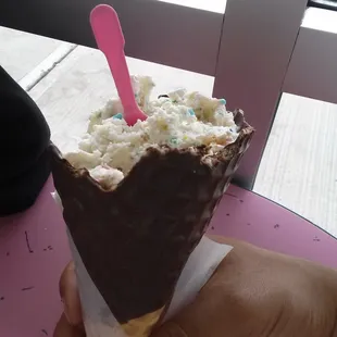 Icing on the cake ice cream in a waffle cone dipped in chocolate