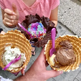 a little girl holding two ice cream cones