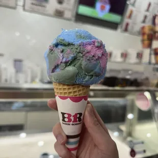 a hand holding a cone of ice cream