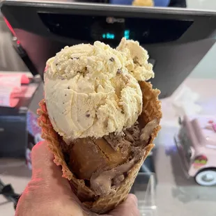 a hand holding a cone of ice cream