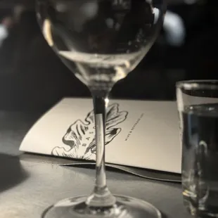 a glass of water and a menu on a table