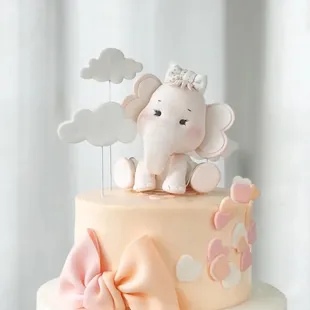 a baby elephant on top of a cake