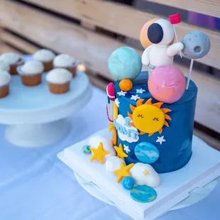 a space themed cake and cupcakes