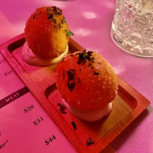 two small sandwiches on a wooden tray