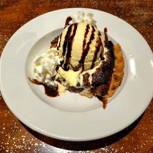 Toll House pie with vanilla ice cream, whipped cream, and chocolate drizzle.