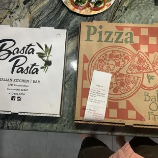 a box of pizza and a plate of salad