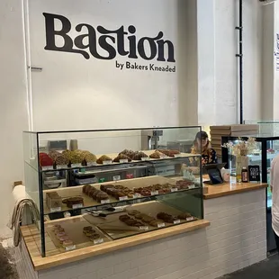 a woman standing in front of a bakery counter